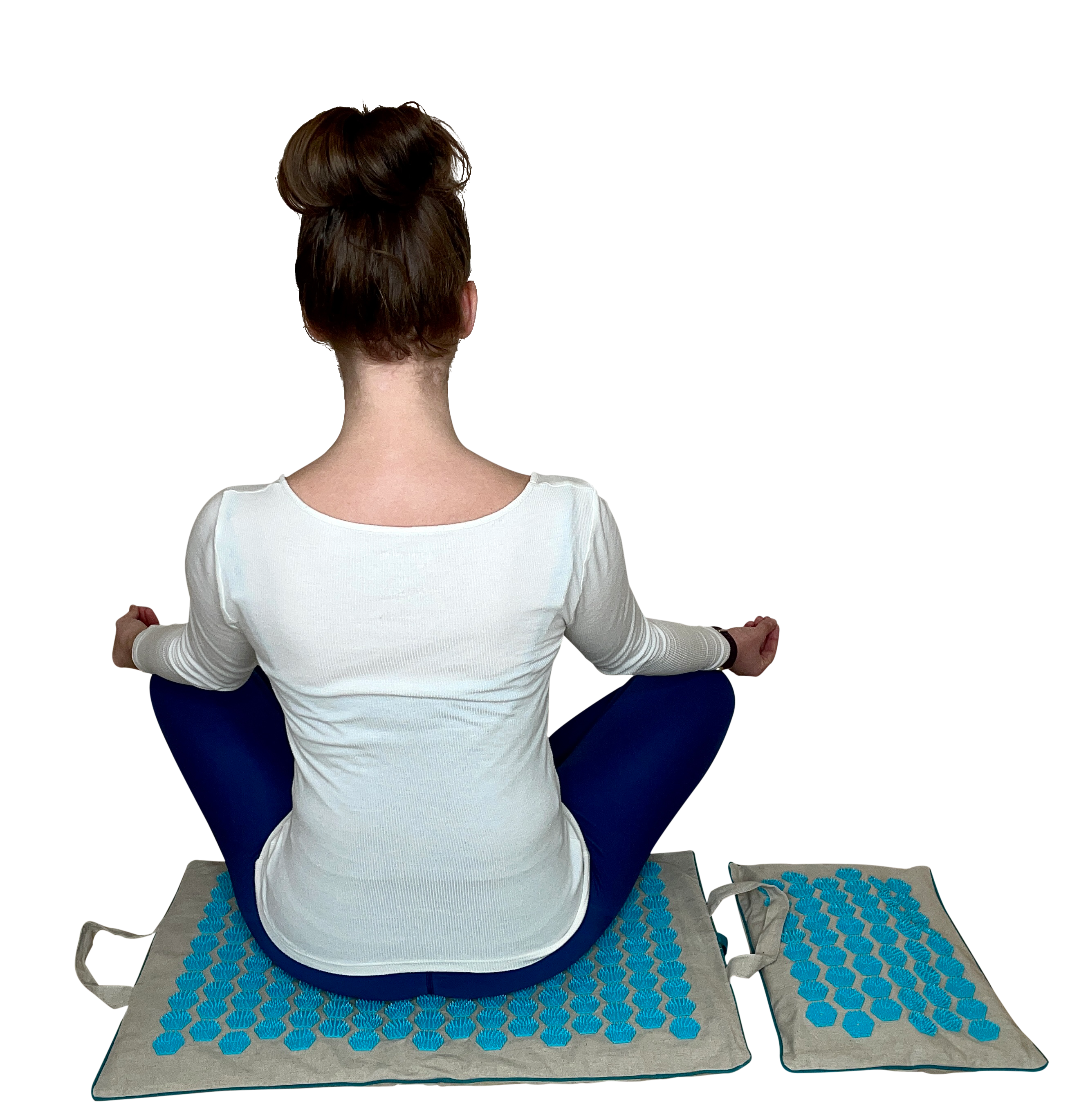 Frau sitzt in einer Meditationshaltung auf einer Akupressurmatte von Mental-High, die auf ihrem Rücken wirkt, während sie ihre Beine gekreuzt hat und die Hände in ihrem Schoß ruhen.